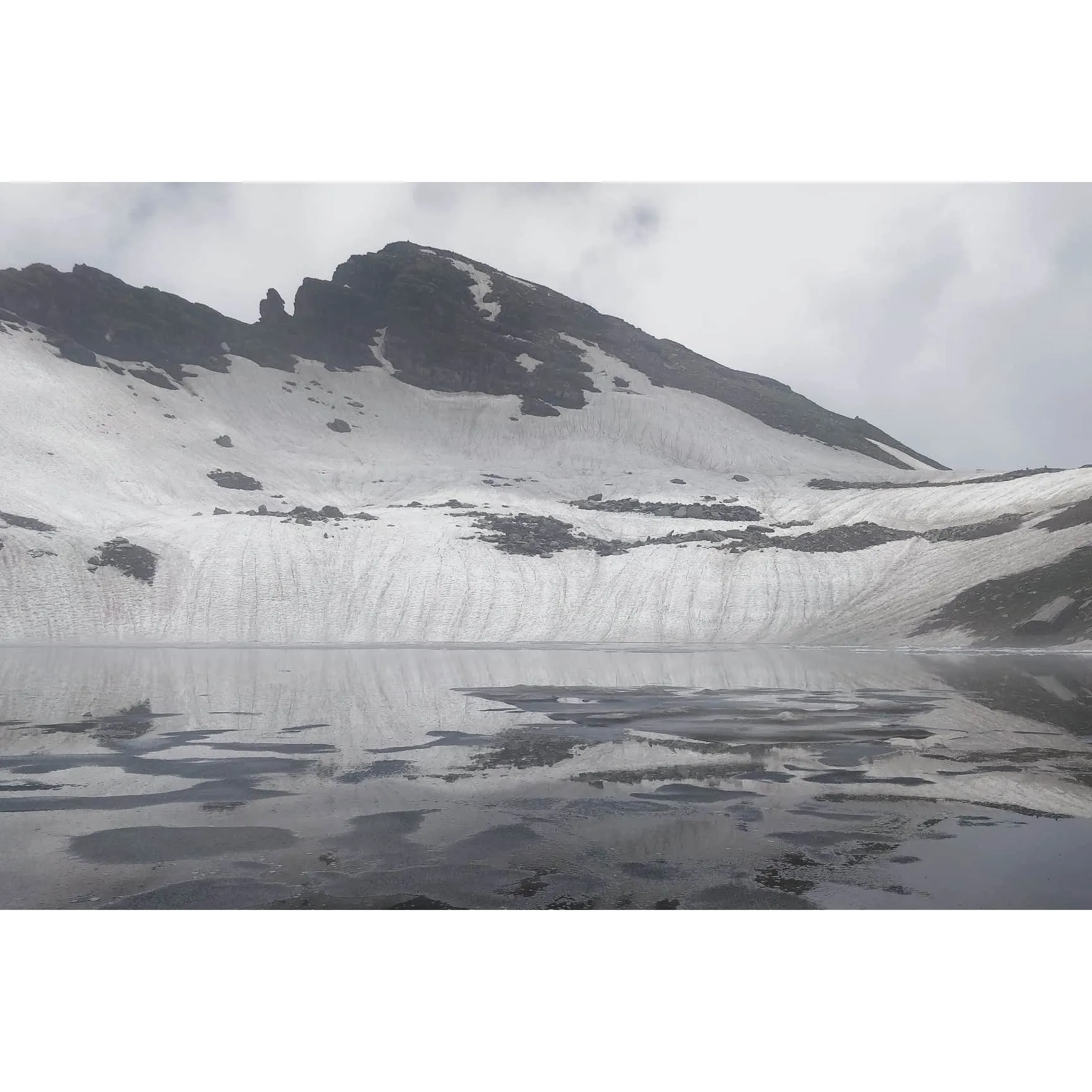 Bhrigu Lake at the summit of the trek covered in fog and some ice